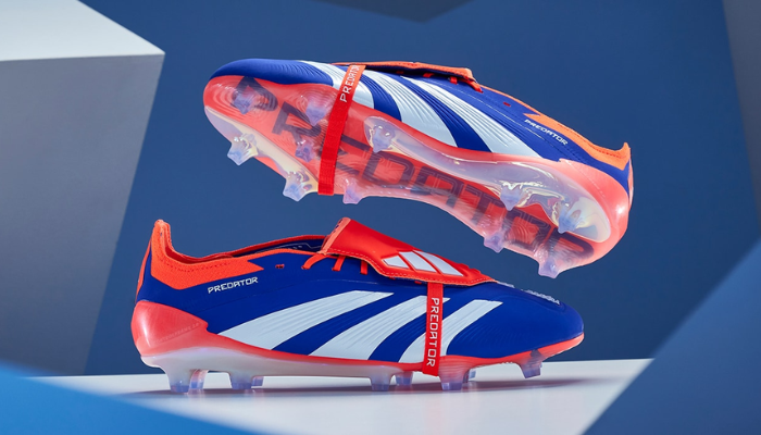 chuteira adidas Predator 24 Foldover Tongue FG na cor azul predominante, com detalhes em laranja e branco. A chuteira possui cano alto estiloso e cadarço centralizado.